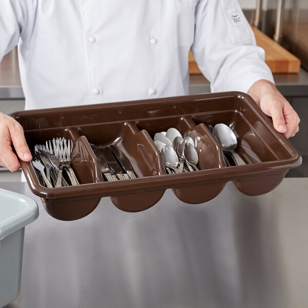 A brown plastic container with compartments holding utensils.