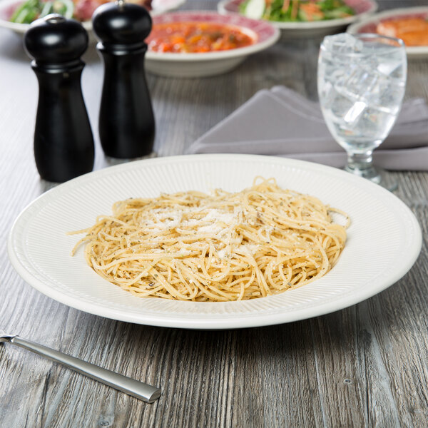 A Tuxton Hampshire pasta bowl filled with spaghetti on a table.