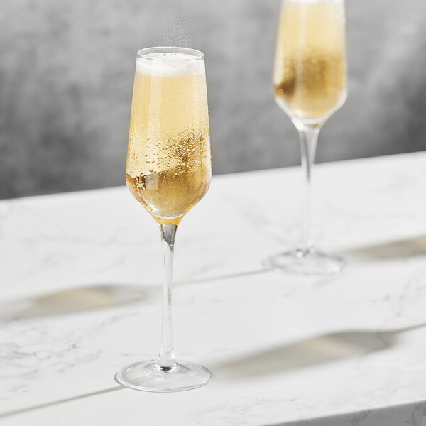 Two Della Luce Astro champagne flutes on a table.