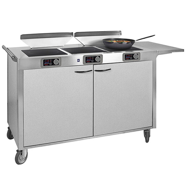 A large stainless steel Spring USA induction cooking cart with pans on top.