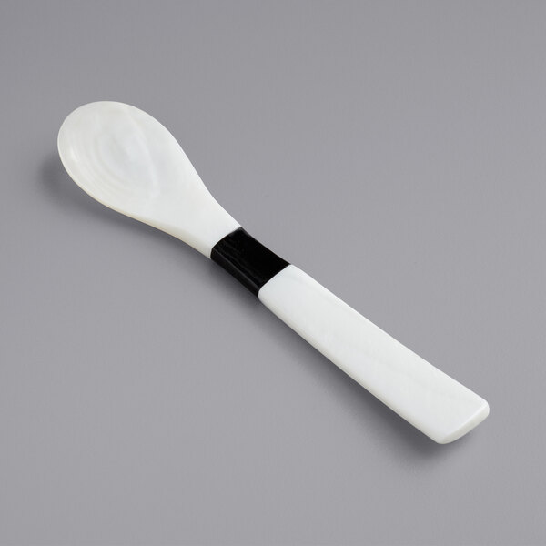 A white spoon with a black Mother of Pearl handle.