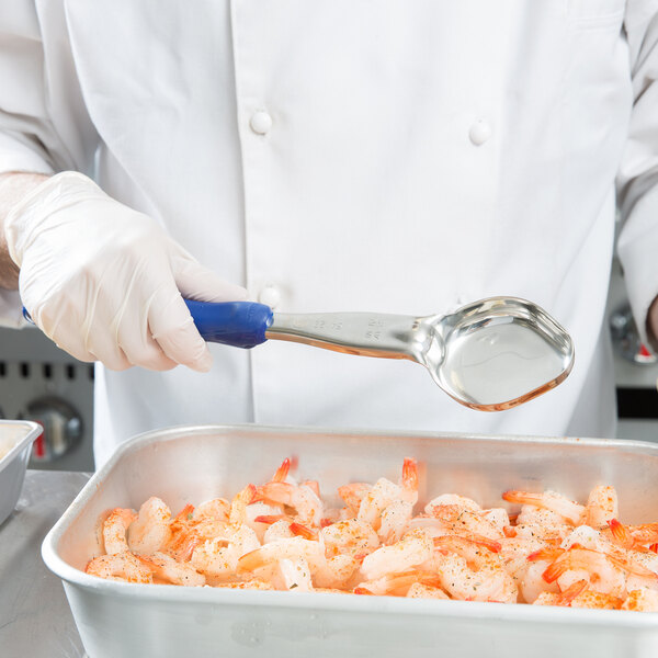 A person uses a Vollrath Blue Solid Oval Spoodle to serve shrimp.