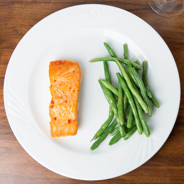 A CAC Super White porcelain plate with salmon and green beans on a table.