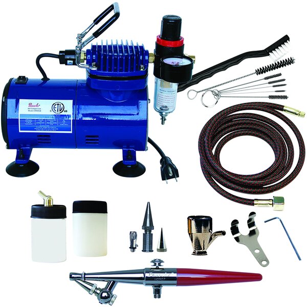 A blue Paasche air compressor with various tools and accessories including a red and black airbrush.