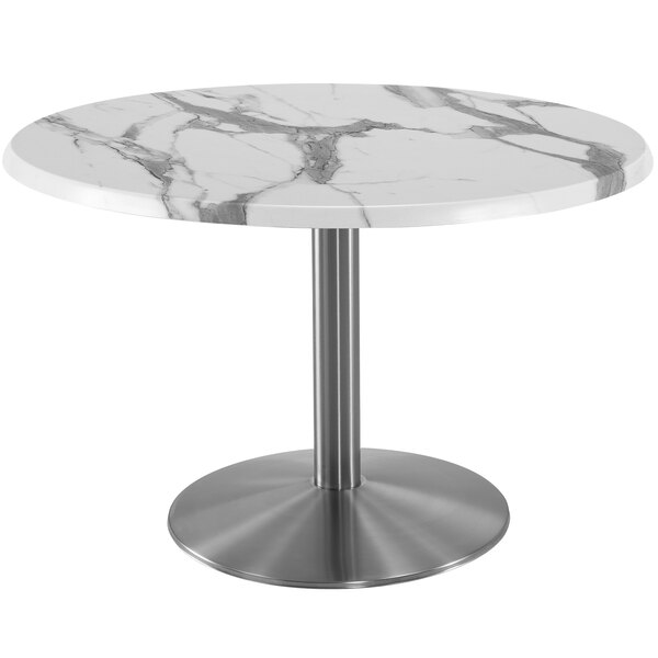 A round white marble table with a stainless steel base.