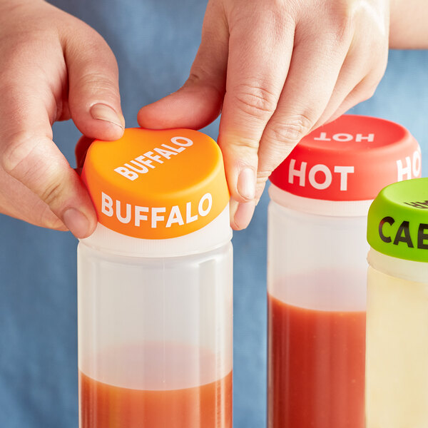 A person using a "Buffalo" silicone lid on a squeeze bottle.