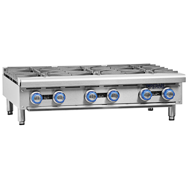 A stainless steel Imperial countertop with blue knobs on a 24" Liquid Propane 4 burner hot plate.