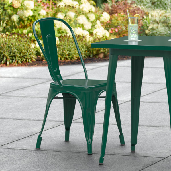 A green Lancaster Table & Seating outdoor cafe chair and table.