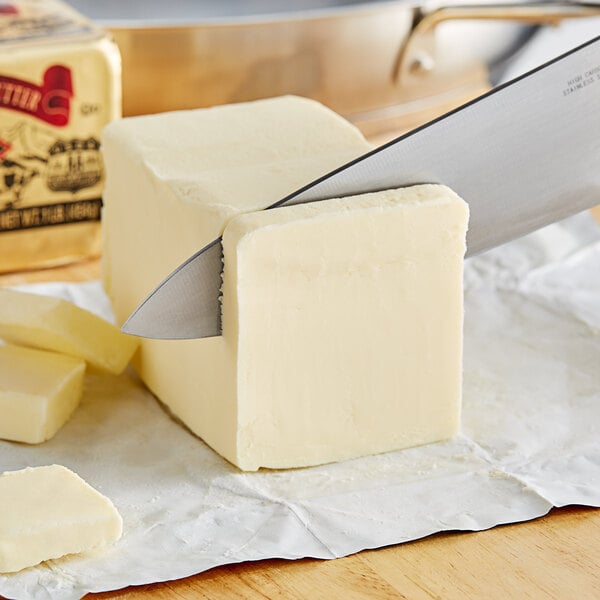 A knife cutting a block of Wuthrich European butter