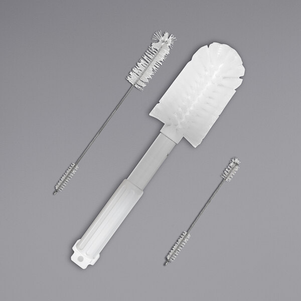 A SaniServ brush kit with a white brush and two other brushes, one with white bristles.