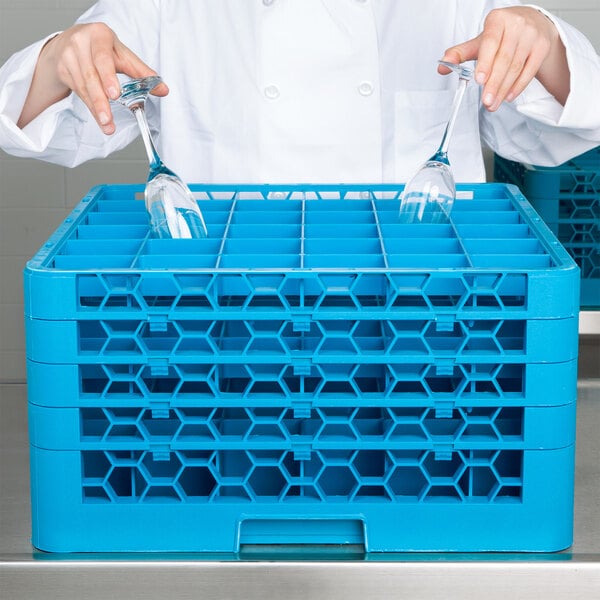 A chef holding a Carlisle blue glass rack with glasses.