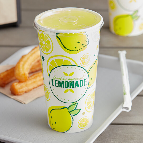 A Carnival King lemonade cup with a lid and a straw slot with a straw and lemons on the lid.