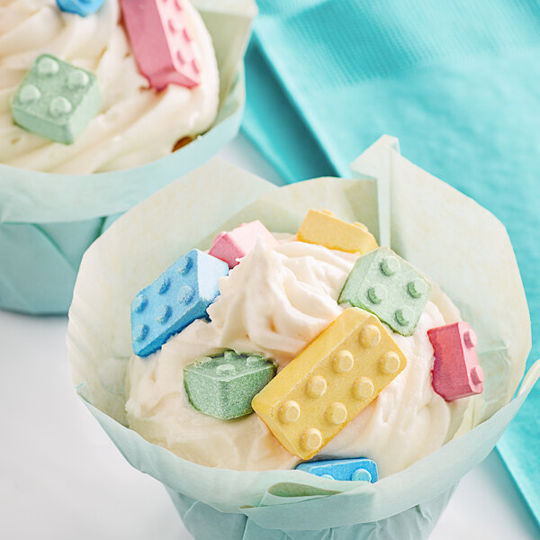 A cupcake with white frosting and Candy Blox on top.