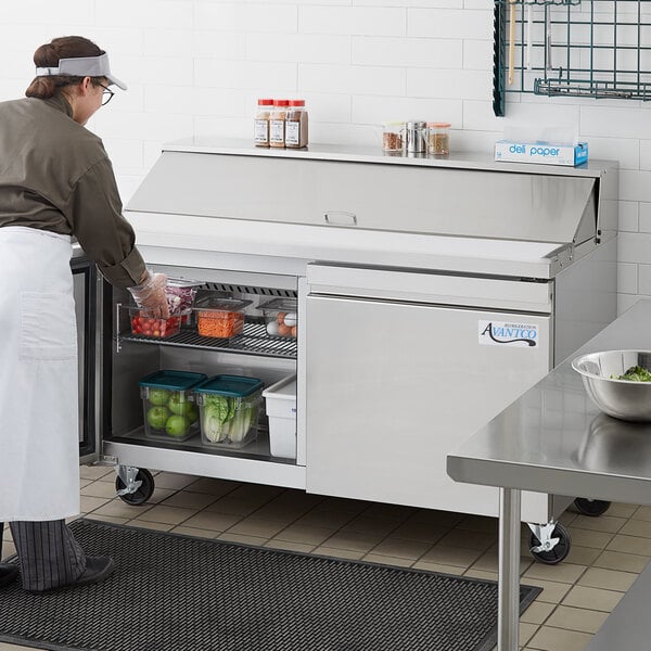 An Avantco Stainless Steel Refrigerated Sandwich / Salad Prep Table with food inside, in a school kitchen.