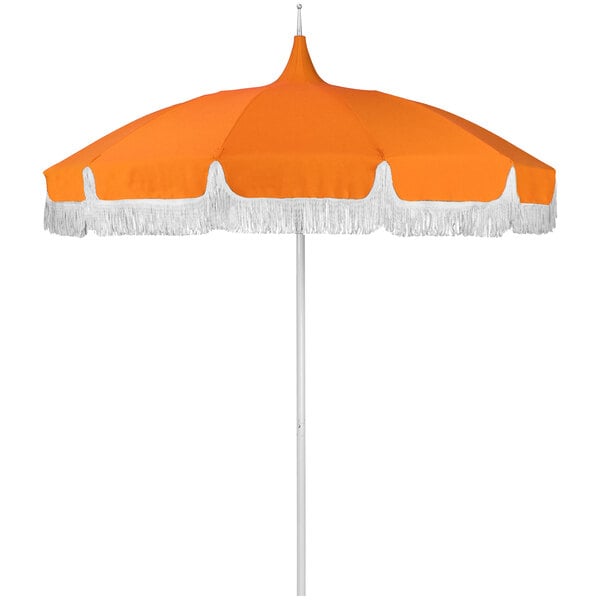 An orange and white umbrella with a pointy top and white fringe.