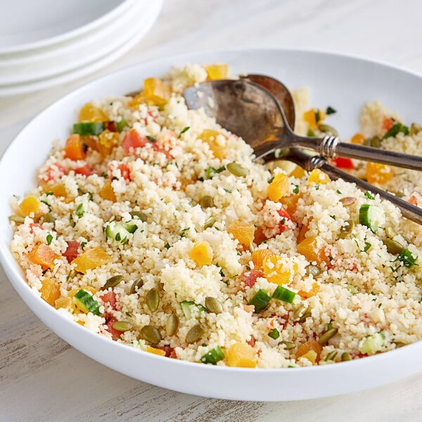 A bowl of Bob's Red Mill Golden Couscous with vegetables and a spoon.