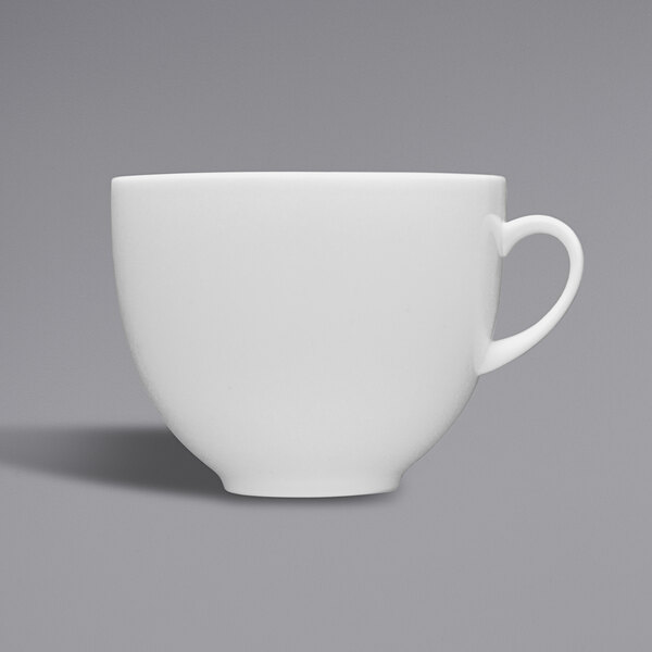 A close-up of a Fortessa Caldera bright white china cup with a handle.