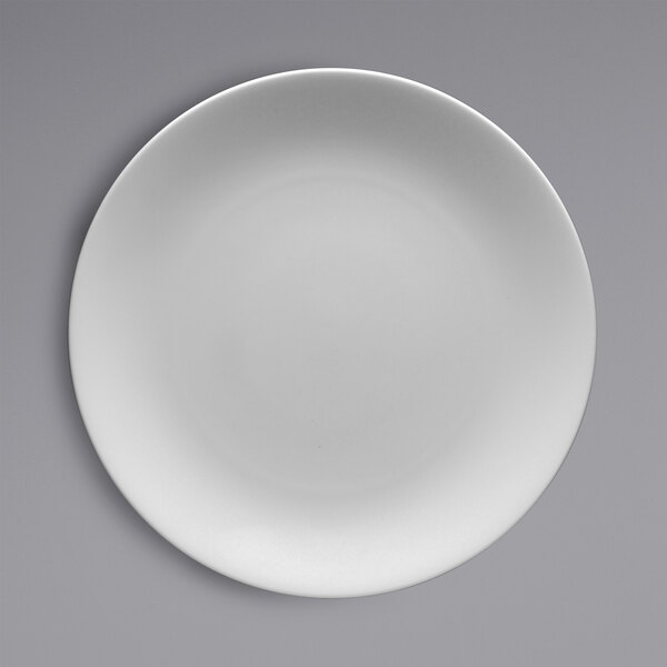 A white Fortessa Caldera china plate with a white rim on a gray surface.