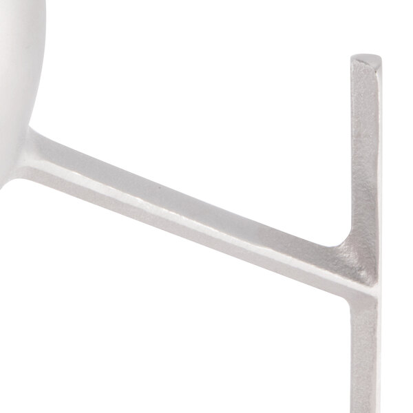 A close-up of a white metal flat beater.