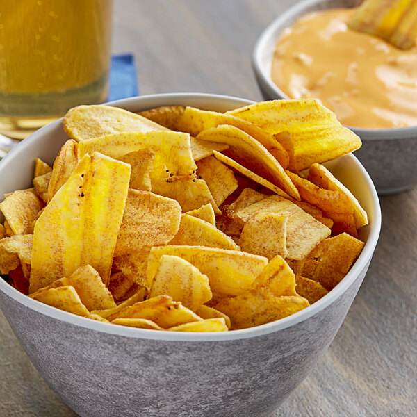 A bowl of Goya Plantain Strips on a table with dip.