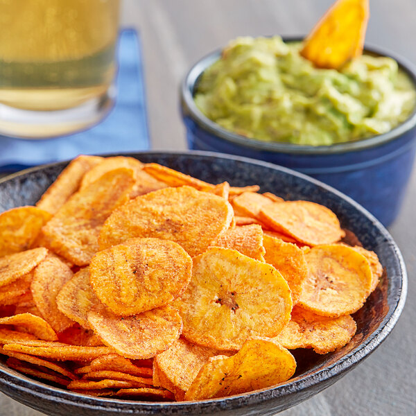A bowl of Goya Hot and Spicy Plantain Chips with guacamole.