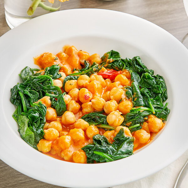 A bowl of Goya chickpeas and spinach on a table.