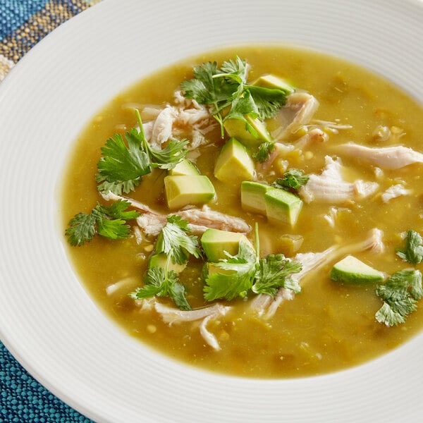 A bowl of soup with chicken, avocado, and Goya Fire Roasted Diced Green Chiles.
