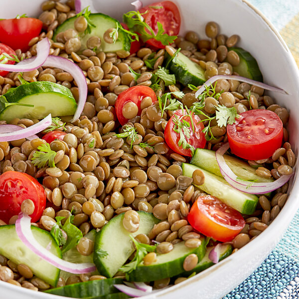 A bowl of lentil salad with Goya lentils, cucumbers, tomatoes, and onions.