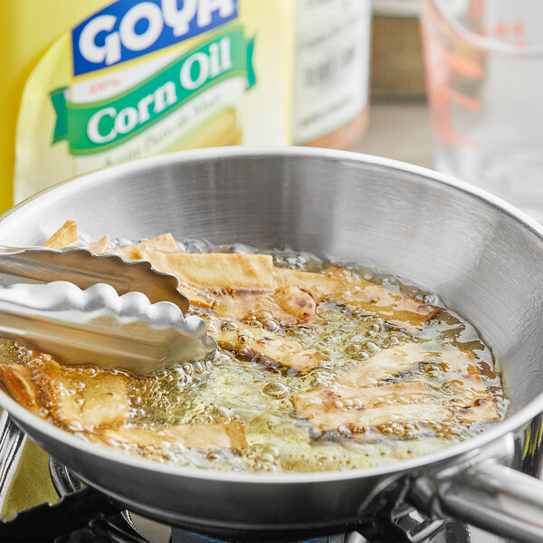 A pan of food cooking in Goya Pure Corn Oil on a kitchen counter.
