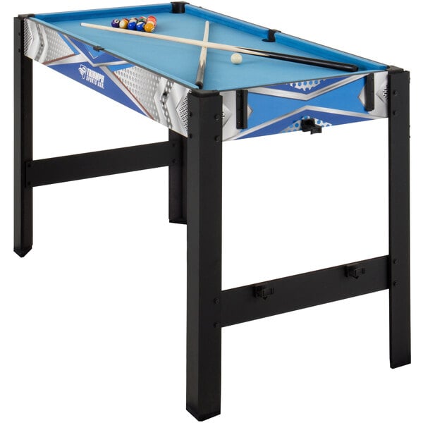 A Triumph 13-in-1 Combo Game Table with pool balls and a cue stick on it.