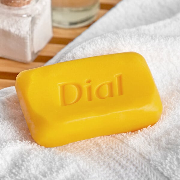 A yellow Dial bar of soap on a white towel.