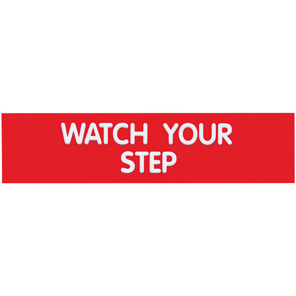 A red rectangular sign with white text that says "Watch Your Step"
