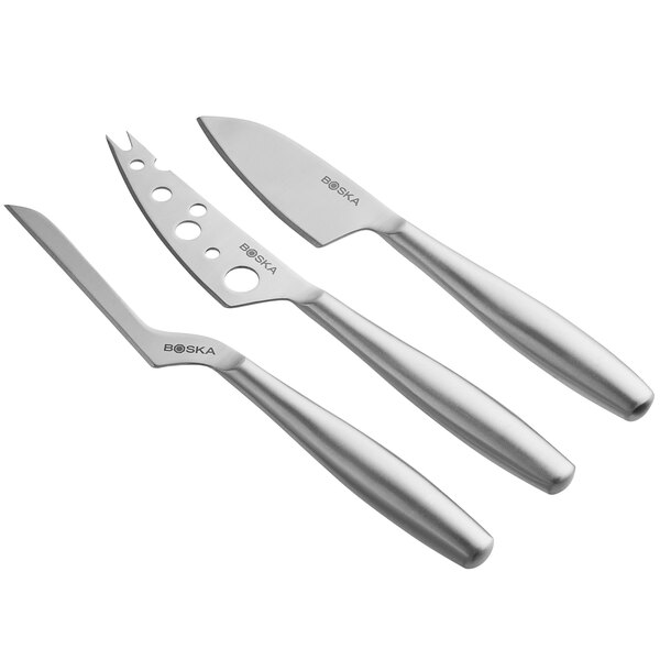 A group of silver Boska stainless steel cheese knives with handles.