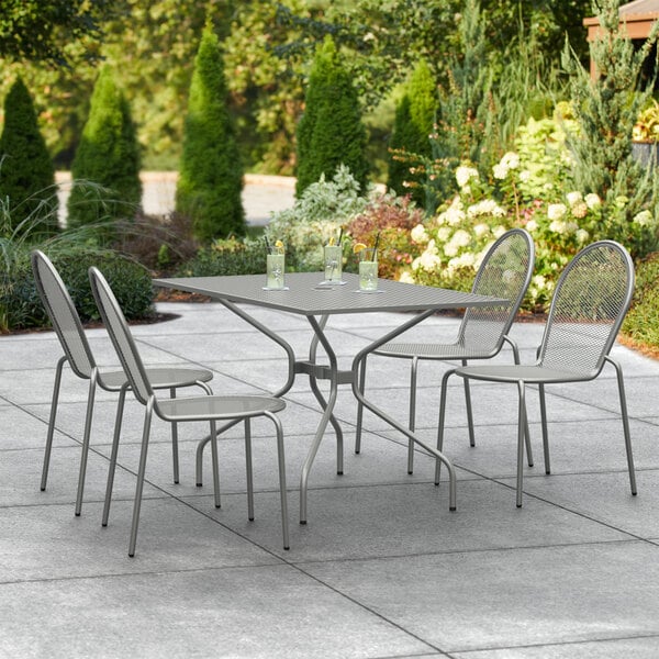 A Lancaster Table & Seating outdoor table and chairs on a patio.