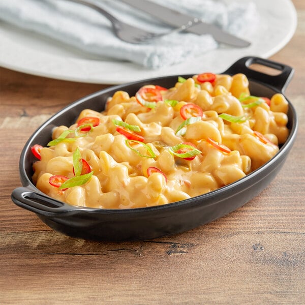 An American Metalcraft black faux cast iron melamine casserole dish with macaroni and cheese on a table.