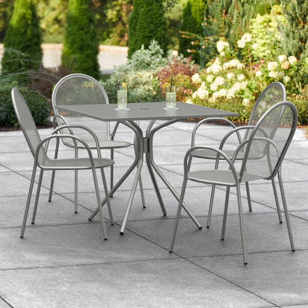 A Lancaster Table & Seating Harbor Gray outdoor patio table with four chairs.