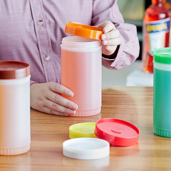 A person holding a Choice plastic container with different colored lids.