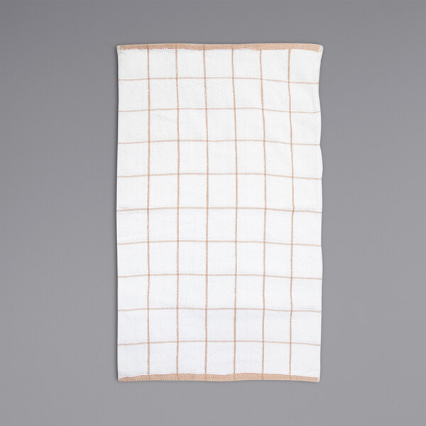 A tan kitchen towel with a white windowpane pattern.