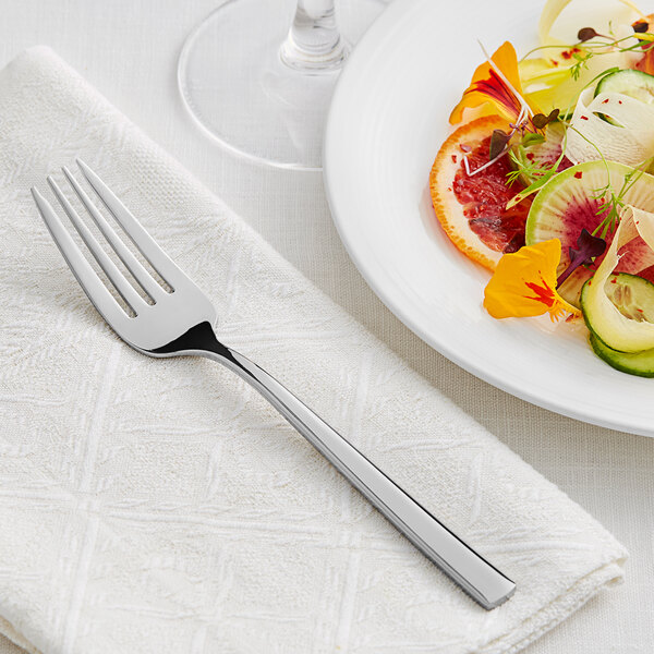 An Acopa Skyscraper stainless steel fork on a plate with salad, fruit, and vegetables.