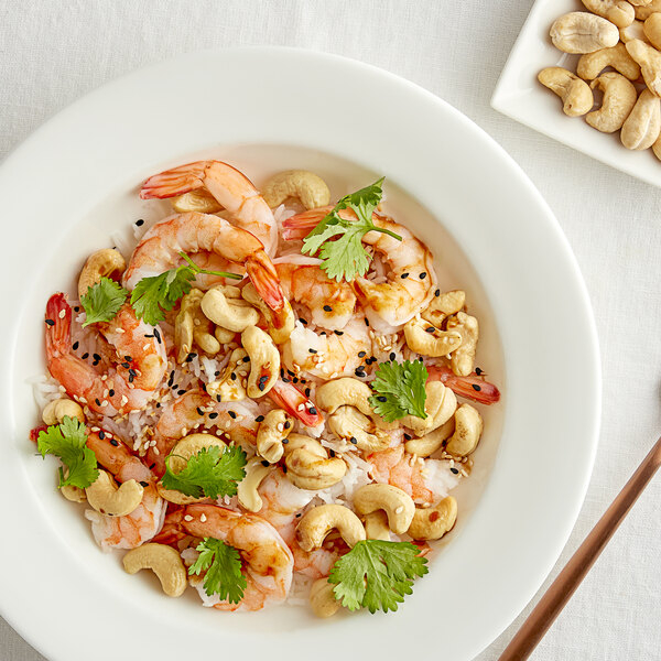 A bowl of food with shrimp and cashews.