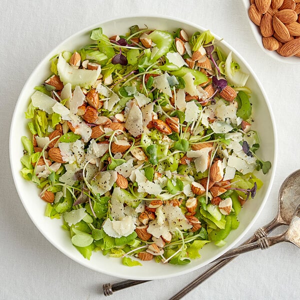 A bowl of salad with almonds and cheese.