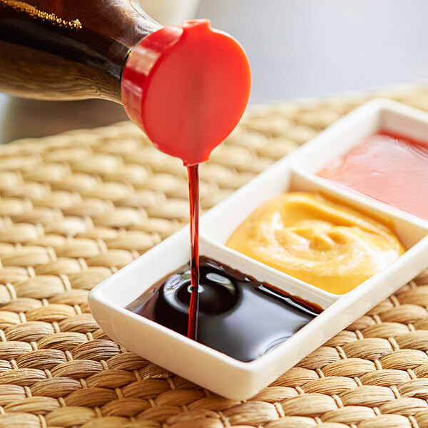A person pouring Lee Kum Kee Less Sodium Soy Sauce into a container.