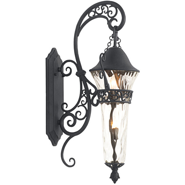 A Kalco black wrought iron wall sconce with clear glass shade.