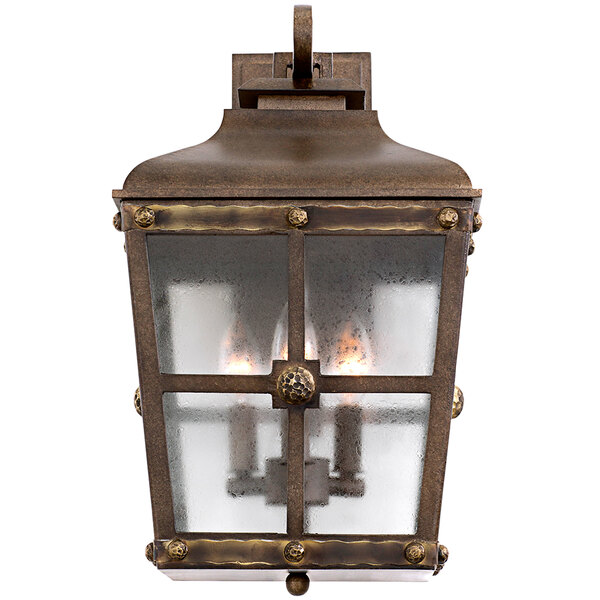 A Kalco Sherwood Medium Wall Sconce with an aged bronze finish and glass shade.