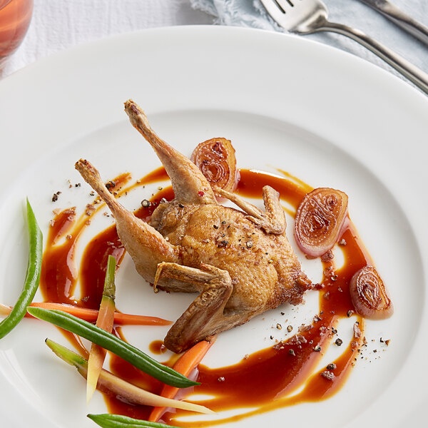 A plate with a fork and knife next to a Manchester Farms semi boneless quail.