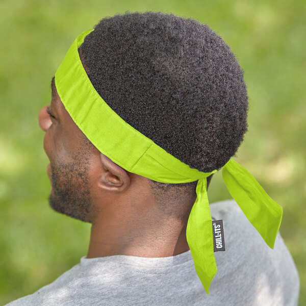 A man wearing a lime green Ergodyne evaporative cooling bandana.
