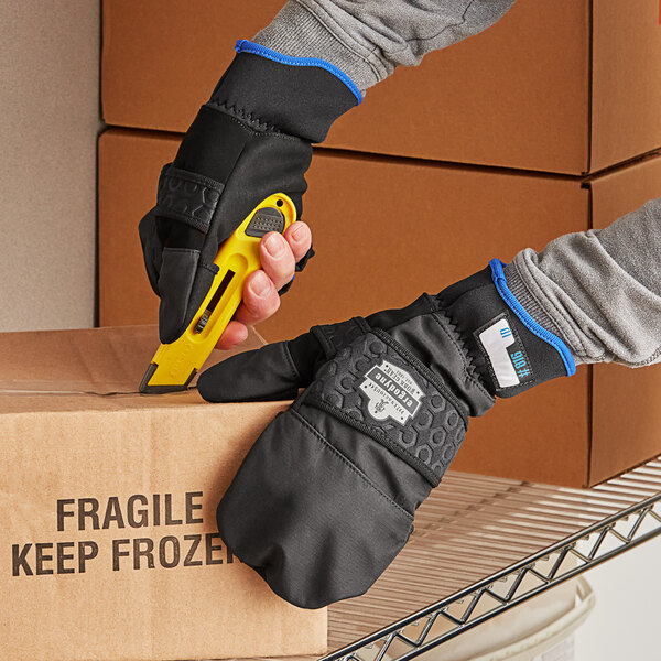 A person using Ergodyne ProFlex thermal fingerless work gloves to cut a box.