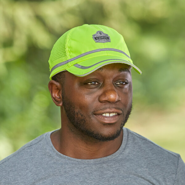 A man wearing an Ergodyne lime green high visibility baseball cap.