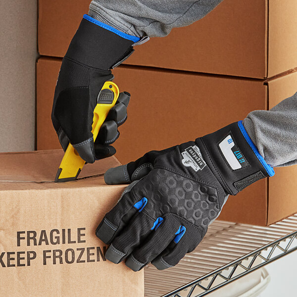 A person wearing Ergodyne ProFlex thermal work gloves cutting a box.