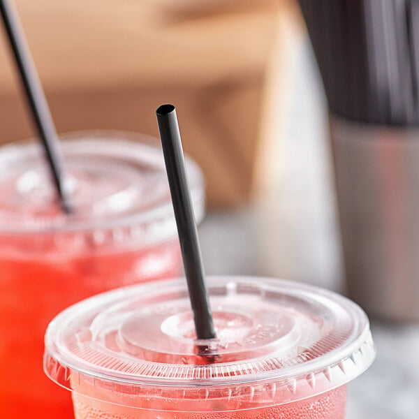 A close-up of a Choice black unwrapped straw in a plastic cup with a lid and straw.